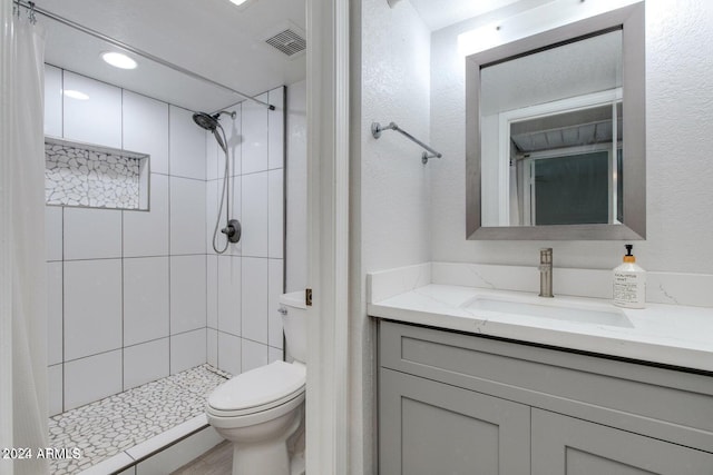 8020 E Thomas Rd Unit 119, Scottsdale, AZ 85251 - bathroom with vanity, visible vents, a tile shower, and toilet