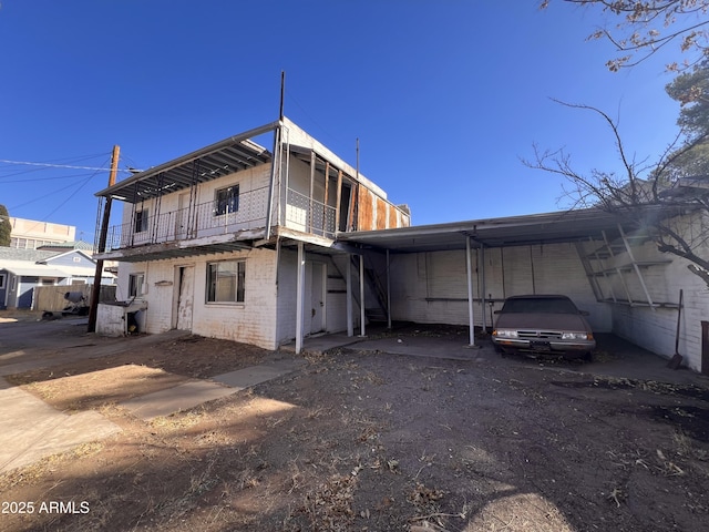 back of house featuring a carport