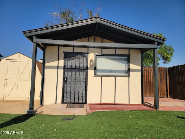 rear view of property featuring an outbuilding and a storage shed