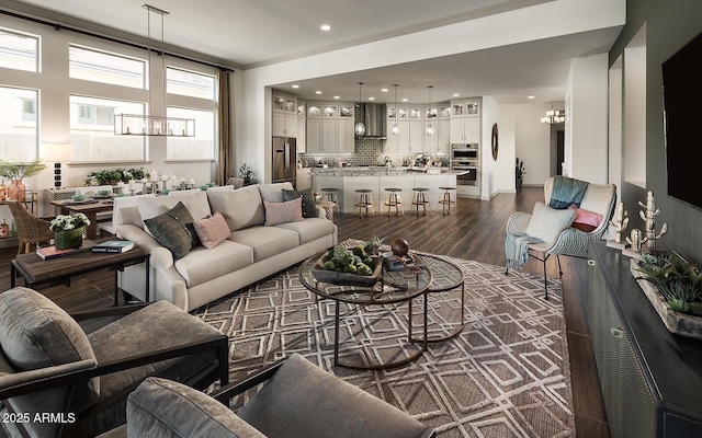 living room featuring a chandelier, ornamental molding, dark wood-style floors, and recessed lighting