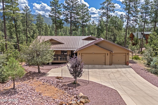 4047 W Forest Ct, Pine, AZ 85544 - view of front of home with metal roof, an attached garage, concrete driveway, a mountain view, and a porch