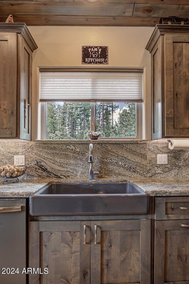 kitchen featuring a healthy amount of sunlight, light stone countertops, decorative backsplash, and stainless steel dishwasher