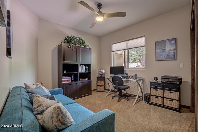 carpeted home office featuring ceiling fan