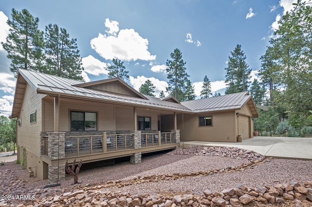 4047 W Forest Ct, Pine, AZ 85544 - back of property with a standing seam roof, metal roof, stone siding, driveway, and a garage