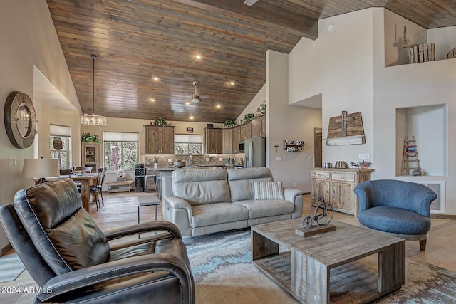 living room featuring ceiling fan with notable chandelier, wood ceiling, high vaulted ceiling, and light hardwood / wood-style flooring