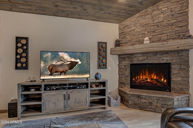 living room with wooden ceiling, light wood-type flooring, vaulted ceiling, and a stone fireplace