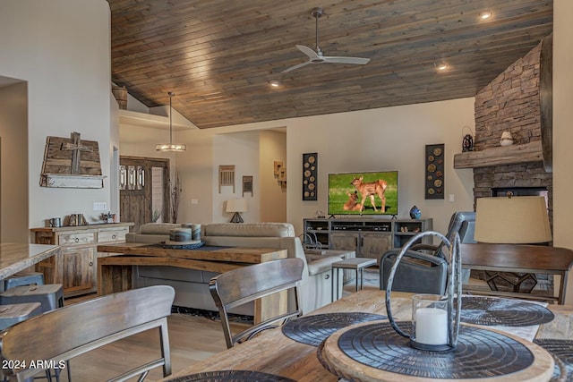 living room featuring high vaulted ceiling, ceiling fan, a fireplace, and wooden ceiling