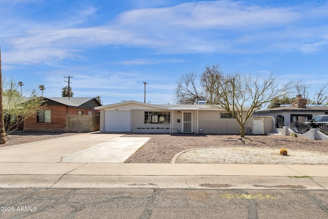 view of front of property with concrete driveway, fence, and an attached garage