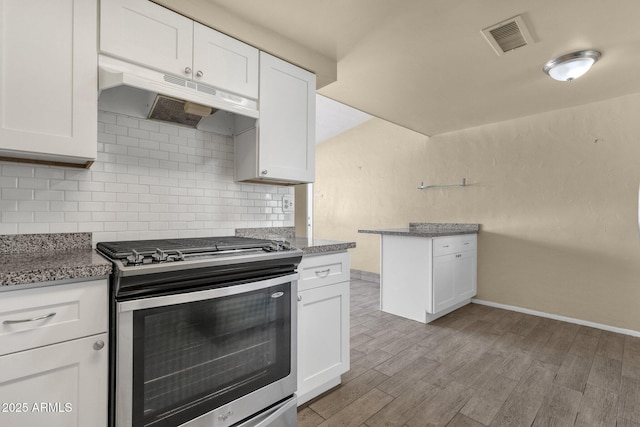 kitchen with light wood finished floors, visible vents, backsplash, gas range, and under cabinet range hood