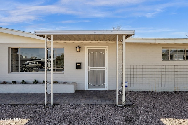 view of exterior entry featuring a patio