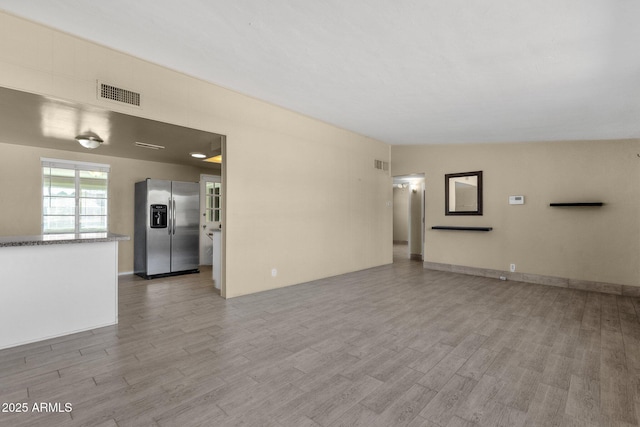 unfurnished living room featuring light wood-type flooring and visible vents