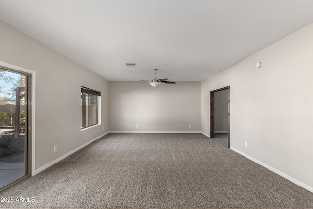 carpeted spare room with visible vents, ceiling fan, and baseboards