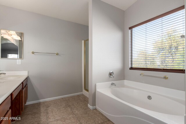 full bathroom featuring a stall shower, baseboards, tile patterned floors, a garden tub, and vanity