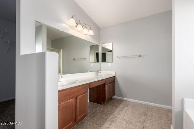 full bath featuring double vanity, baseboards, a sink, and tile patterned floors