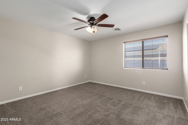 empty room with ceiling fan, dark carpet, visible vents, and baseboards