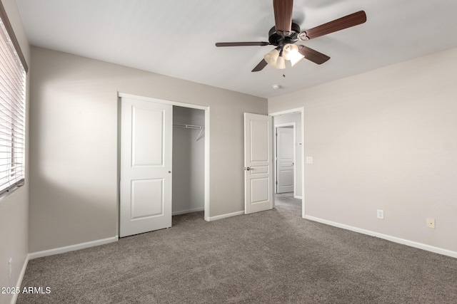 unfurnished bedroom featuring carpet floors, a closet, baseboards, and a ceiling fan