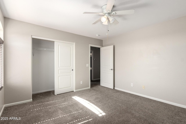 unfurnished bedroom with ceiling fan, dark colored carpet, a closet, and baseboards