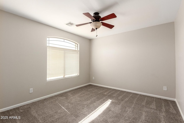 carpeted empty room featuring a ceiling fan, visible vents, and baseboards