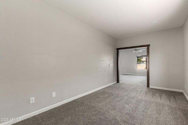 carpeted spare room featuring baseboards