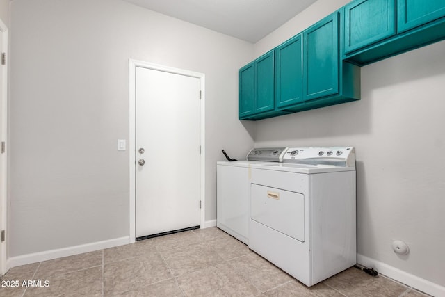 laundry area with washing machine and dryer, cabinet space, and baseboards