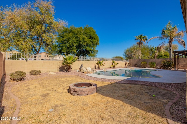 view of swimming pool with an outdoor fire pit and a fenced backyard