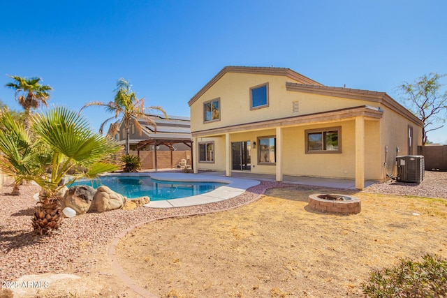 rear view of house featuring a fire pit, a patio, fence, cooling unit, and stucco siding