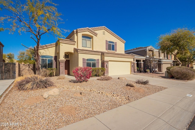 view of front facade featuring driveway, stucco siding, an attached garage, fence, and brick siding