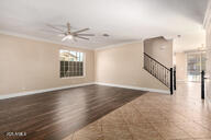 unfurnished living room with baseboards and ornamental molding