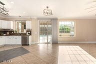 kitchen featuring light tile patterned flooring, baseboards, and white cabinetry