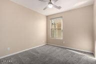 carpeted empty room with ceiling fan and baseboards