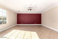 tiled spare room with baseboards and crown molding