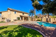 outdoor pool featuring fence and a lawn