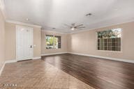 unfurnished living room featuring ornamental molding, baseboards, and wood finished floors