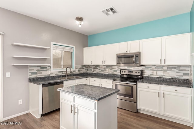 kitchen featuring sink, stainless steel appliances, white cabinets, and a kitchen island