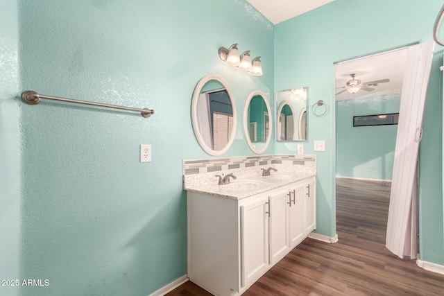 bathroom with tasteful backsplash, vanity, wood-type flooring, and ceiling fan