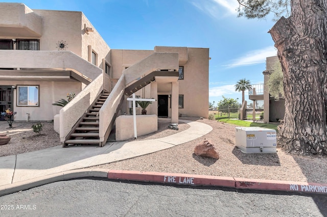 back of house featuring stairway and stucco siding