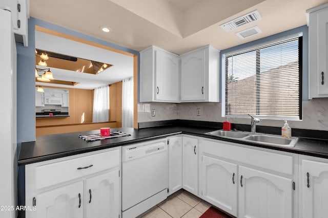 kitchen featuring white cabinetry, sink, light tile patterned floors, a raised ceiling, and white appliances