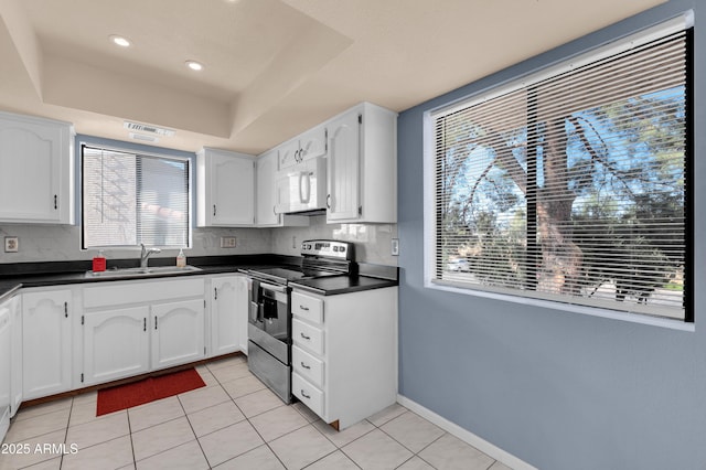 kitchen featuring a tray ceiling, sink, stainless steel electric range, and white cabinetry