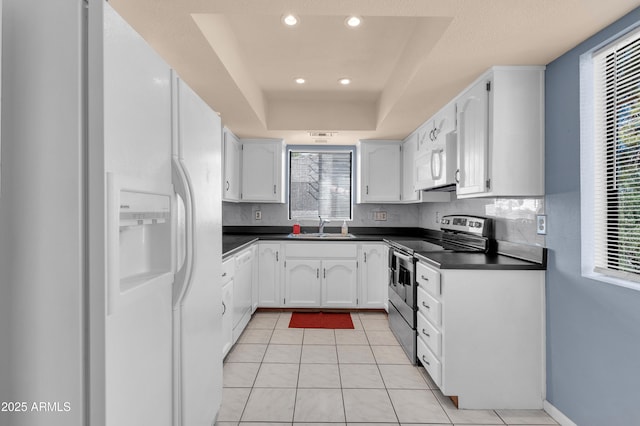 kitchen with sink, white appliances, light tile patterned floors, white cabinets, and decorative backsplash