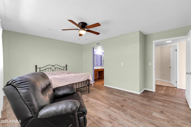 bedroom featuring a textured ceiling, light wood-type flooring, and visible vents