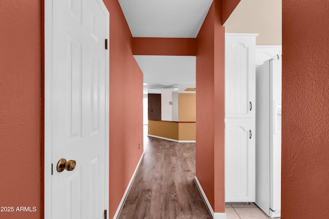 hall with wood finished floors and baseboards