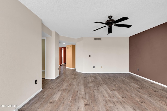 empty room featuring ceiling fan, a textured ceiling, and light wood-type flooring