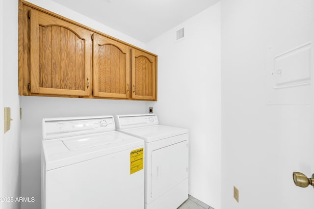 laundry room with visible vents, separate washer and dryer, and cabinet space