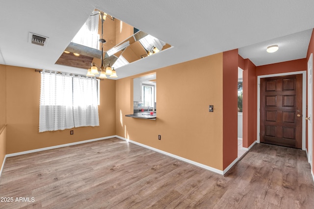 foyer entrance featuring a notable chandelier and light hardwood / wood-style flooring