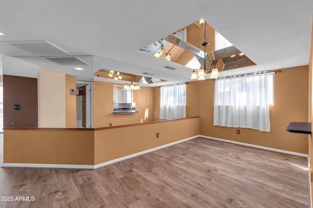 spare room with wood-type flooring and a notable chandelier