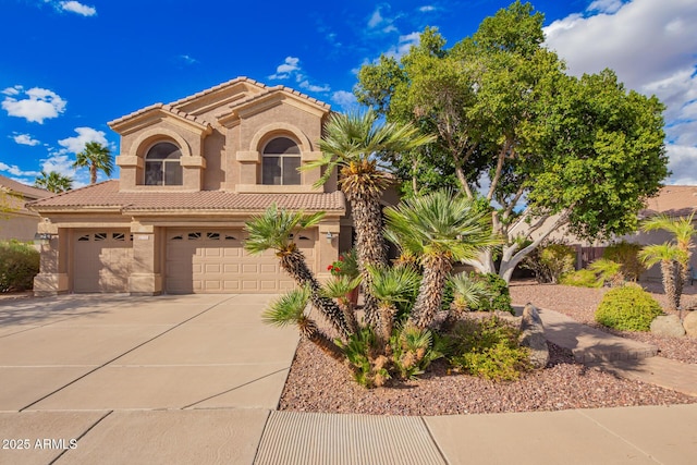 mediterranean / spanish-style home featuring stucco siding, a tiled roof, concrete driveway, and a garage