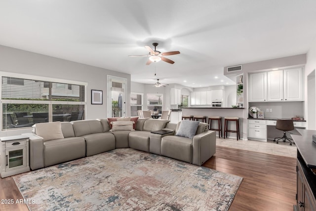 living room with light wood-style flooring, recessed lighting, visible vents, and ceiling fan