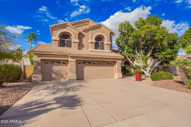 mediterranean / spanish-style home featuring fence, driveway, stucco siding, a garage, and a tile roof