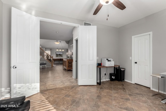 interior space with visible vents, a ceiling fan, and baseboards