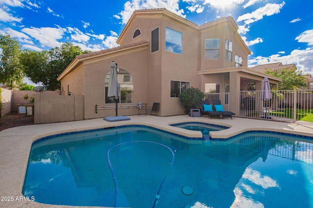 view of swimming pool featuring an in ground hot tub, fence, a fenced in pool, and a patio